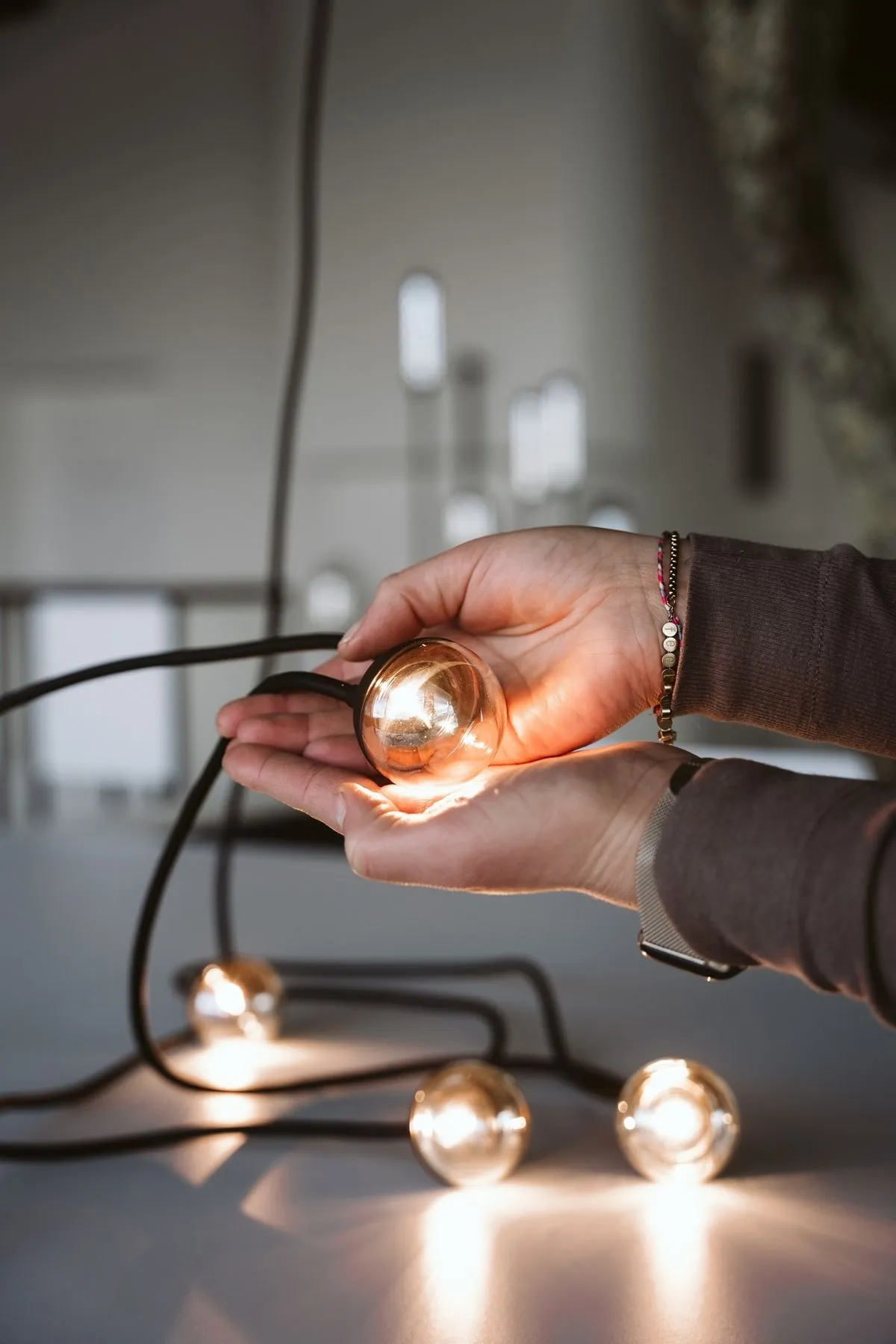 Électricien réglant une suspension à ampoules décoratives