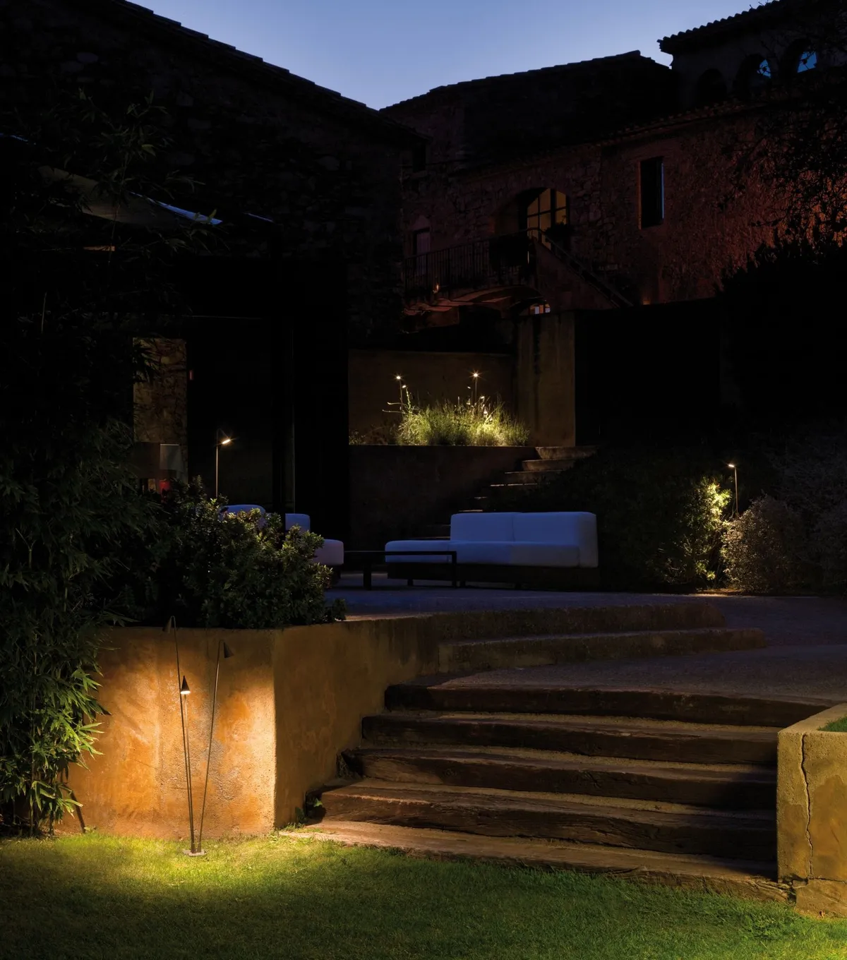 Habitation et jardin mis en lumière la nuit par une installation extérieure