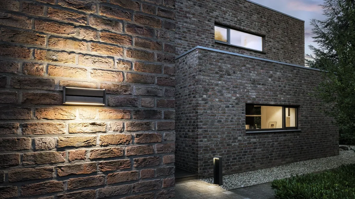 Appliques de façade en pied de mur, matière révélée par la lumière rasante.